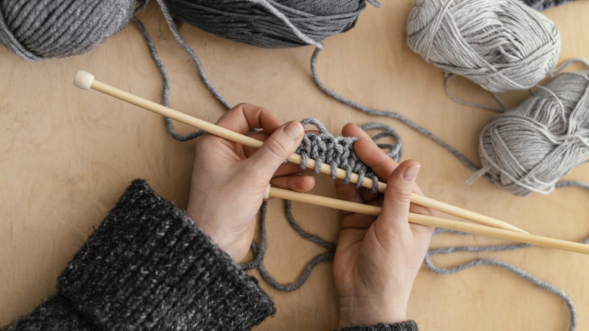 top-view-hands-holding-knitting-needles